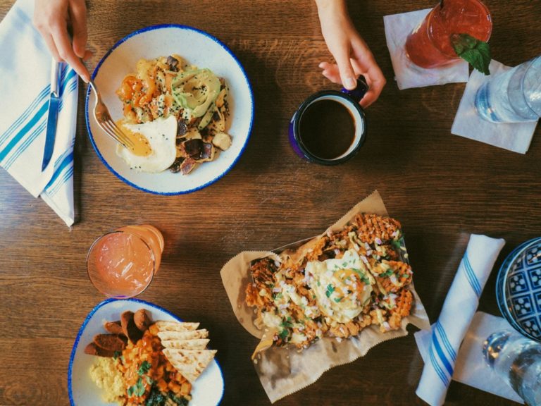 An overhead shot of two brunch dishes and coffee on the table